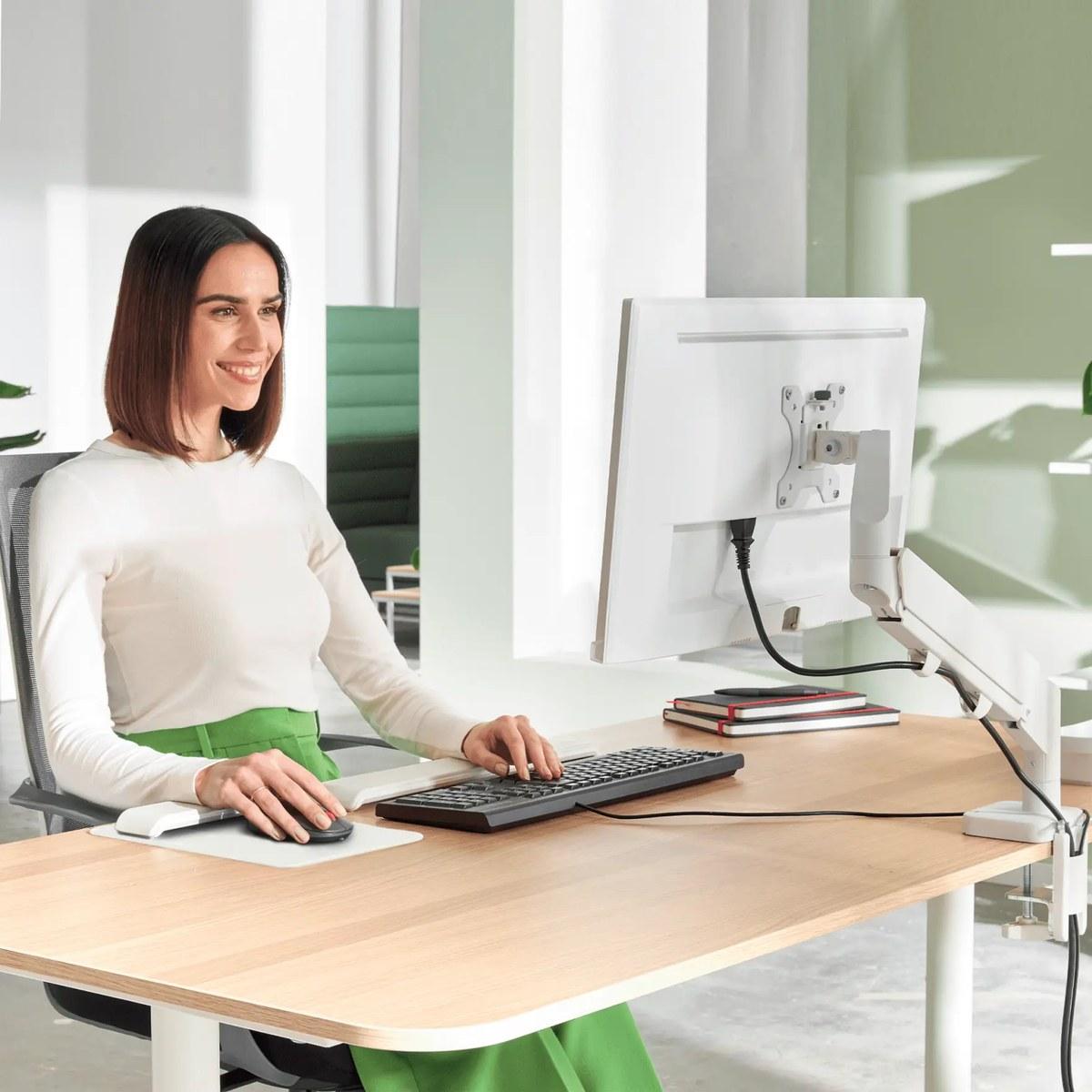 Braço articulado de secretária para um monitor Leitz Ergo em uso