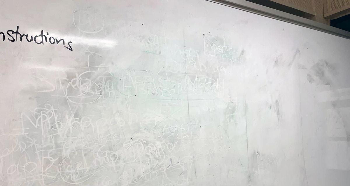 Pizarra blanca manchada, con la sombra de lo que estuvo escrito sin salir de la superficie